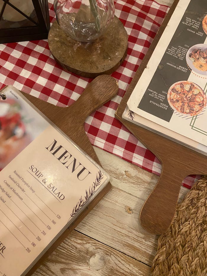 Cozy restaurant table with menu, checkered tablecloth, and wooden decor.